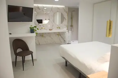 a white bedroom with a bed and a mirror at Gran Hotel Toledo in Onda