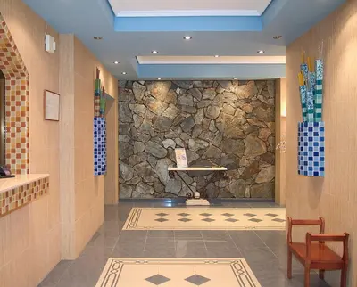 a lobby with a stone wall and a table at Hotel L'Escala in Cullera