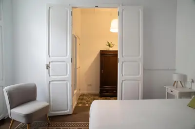 a room with a door and a chair and a table at ABCyou Bed&Breakfast in Valencia