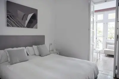 a white bedroom with a white bed and a window at ABCyou Bed&Breakfast in Valencia