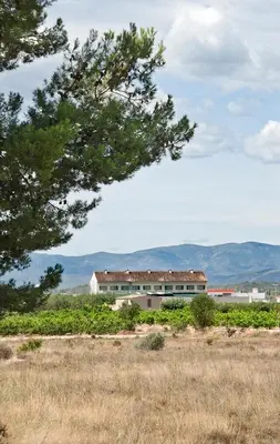 a building in the middle of a field with trees at Hotel Puerta de la Serrania in Lliria