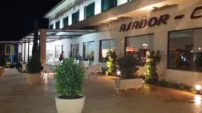 a building with tables and chairs in front of it at Hotel Puerta de la Serrania in Lliria