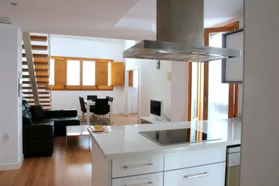 a kitchen and living room with a stove top oven at Edificio Palomar - PalomarGroup in Valencia
