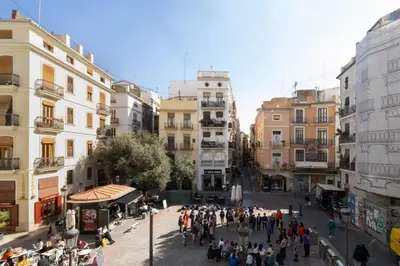 a crowd of people walking down a street in a city at Home Youth Hostel by Feetup Hostels in Valencia