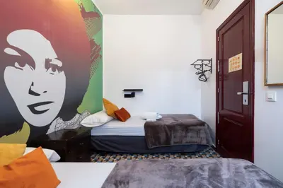 a room with a bed with a painting on the wall at Home Youth Hostel by Feetup Hostels in Valencia