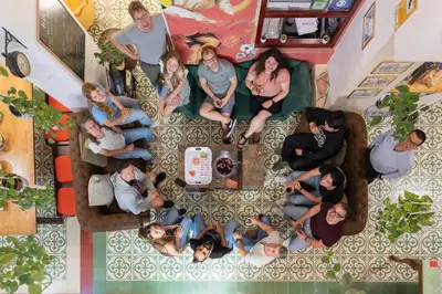 an overhead view of a group of people sitting around a table at Home Youth Hostel by Feetup Hostels in Valencia