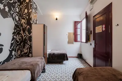 a room with two beds and a door at Home Youth Hostel by Feetup Hostels in Valencia