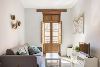 a living room with a couch and a tv at Macflats Valencia Puerto in Valencia
