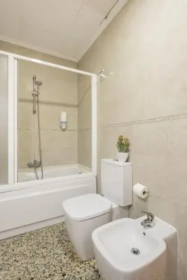 a bathroom with a toilet and a tub and a sink at Macflats Valencia Puerto in Valencia