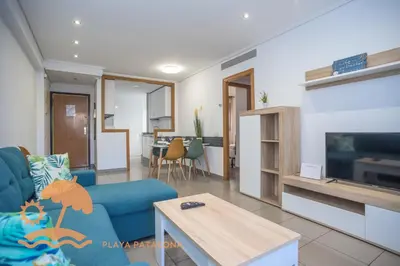 a living room with a blue couch and a tv at Patacona Relax & Resort Apartments in Valencia