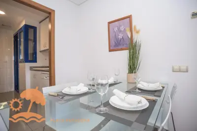 a dining room with a glass table with wine glasses at Patacona Relax & Resort Apartments in Valencia