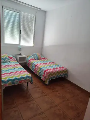 two beds sitting in a room with a window at Adosado Calle Mar Cantabrico in Puebla de Vallbona