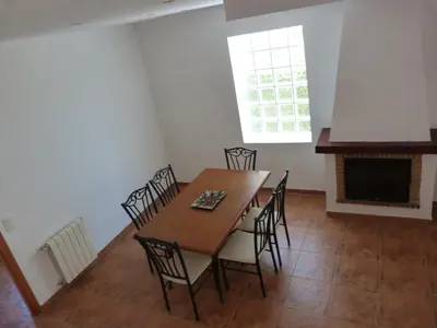 a dining room with a table and chairs and a fireplace at Adosado Calle Mar Cantabrico in Puebla de Vallbona