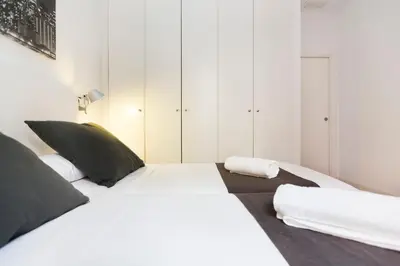 a bedroom with a bed with white sheets and black pillows at Total Valencia Cathedral in Valencia