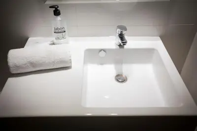 a bathroom sink with a bottle of alcohol and a towel at Total Valencia Cathedral in Valencia