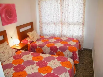 a bedroom with two beds and a window at Apartamentos Milenio in Cullera