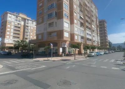 an empty street with a tall building on a city street at Apartamentos Milenio in Cullera