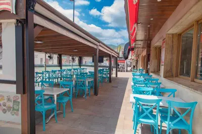 a row of blue tables and chairs on a patio at Hostal Virginia in Favareta