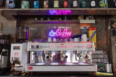 a coffee machine in a kitchen with a neon sign at Hostal Virginia in Favareta