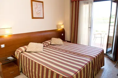a hotel room with a bed with a striped blanket at Torrijos in Cheste