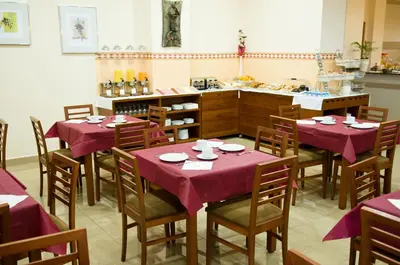 a dining room with tables and chairs with purple tablecloths at Torrijos in Cheste