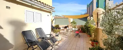 an outdoor patio with chairs and tables and plants at Ático de Lujo Plaza Ayuntamiento in Valencia