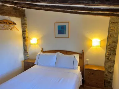 a bedroom with a bed with two night stands and two lights at Apartamentos turísticos 
