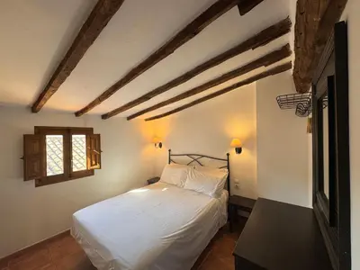 a bedroom with a bed with white sheets and a window at Apartamentos turísticos 