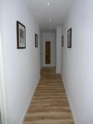 a hallway with white walls and wood floors and a door at Apartment Savoy in Valencia
