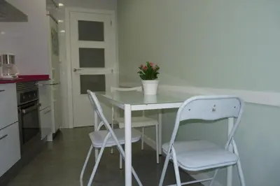 a kitchen with a table and two white chairs at Apartment Savoy in Valencia