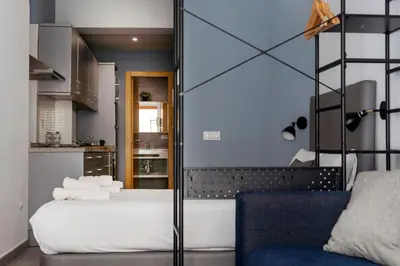 a bedroom with a bed and a blue wall at Welcomer Apartments Valencia in Valencia