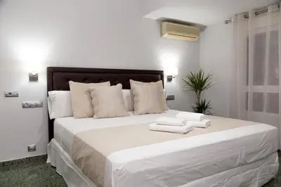 a bedroom with a large white bed with towels on it at MD Vila Barbera in Valencia