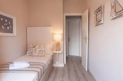 a small bedroom with a bed and a lamp in it at MD Benlliure Cabañal Beach in Valencia