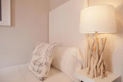 a lamp on a table next to a bed with a pillow at MD Benlliure Cabañal Beach in Valencia