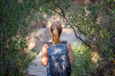 a woman walking down a path with a backpack at Mar de Fulles in Alfondeguilla