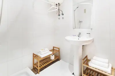 a white bathroom with a sink and a mirror at Victoria Site-Mercat Central in Valencia