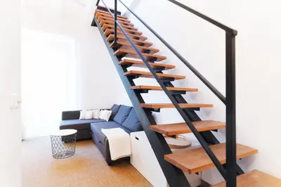 a staircase in a living room with a blue couch at Victoria Site-Mercat Central in Valencia