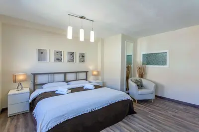 a bedroom with a large bed and a chair at Apartment Malvarrosa Beach Cavite in Valencia