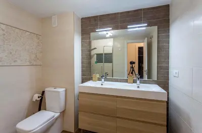 a bathroom with a sink and a toilet and a mirror at Apartment Malvarrosa Beach Cavite in Valencia