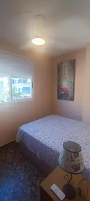 a bedroom with a bed and a table and a window at Pasarela Apartment in Valencia