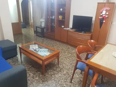 a living room with a coffee table and a tv at Pasarela Apartment in Valencia