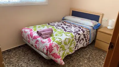a small bedroom with a bed with a blanket at Pasarela Apartment in Valencia