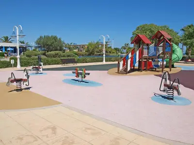 a playground in a park with children playing on slides at ApartUP Patacona Panoramic in Valencia