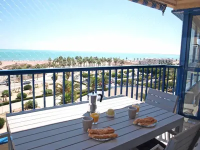 a table on a balcony with a view of the beach at ApartUP Patacona Panoramic in Valencia