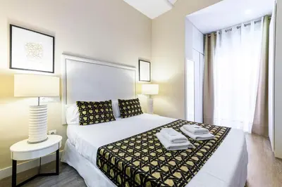 a bedroom with a large bed with two towels on it at MD Pelayo in Valencia