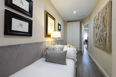 a bedroom with a white bed and some pictures on the wall at MD Pelayo in Valencia