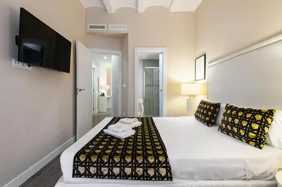 a bedroom with a large bed with a tv on the wall at MD Pelayo in Valencia