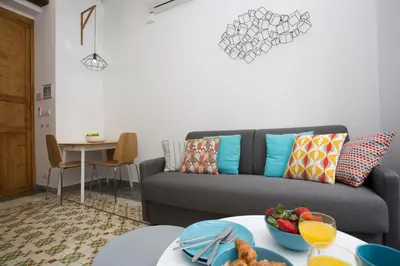 a living room with a couch and a table with a bowl of fruit at Eco-Friendly Apartments in Valencia