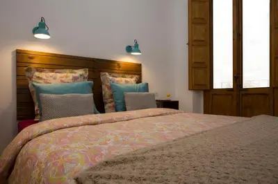a bedroom with a large bed and two chairs at Eco-Friendly Apartments in Valencia