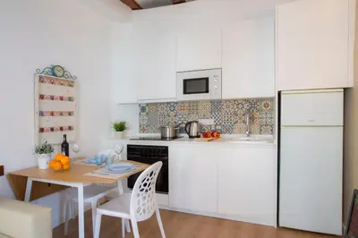 a kitchen with white cabinets and a wooden table at Blanquerias Apartments in Valencia